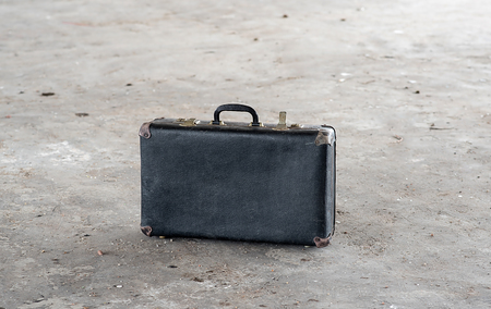 Retro suitcase on the dirty floor in houseの写真素材