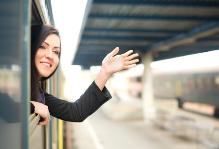 Young woman traveling by train and looking out the windowの写真素材