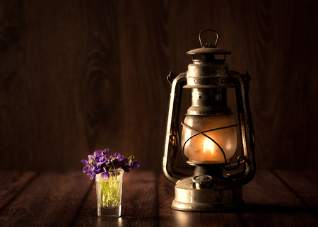 Spring concept with violet and oil lamp on wooden backgroundの写真素材