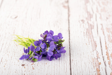 Bouquet of violet flowers on a wooden background