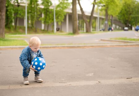 Happy kid playing football in the parkの写真素材