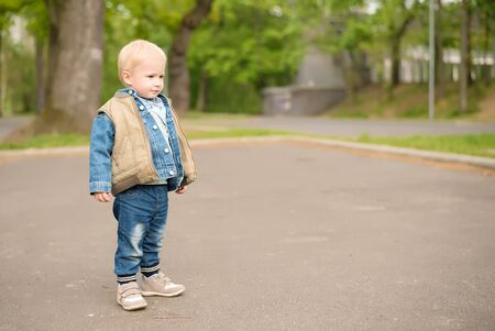 Happy kid standing in the green parkの写真素材