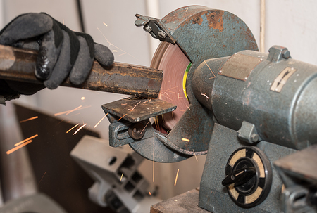 Industrial metal worker use the grinding machine in workshop
