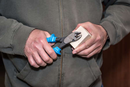 Worker remove a nail with pliers from wooden workpieceの写真素材