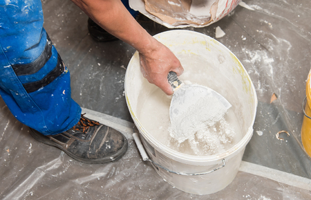 Hands plasterer at work. Application of the plaster on the wallの写真素材