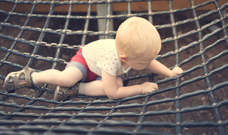 Little blondy boy relaxing in the playgroundの写真素材