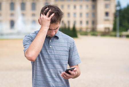 Handsome man received a bad message on phoneの写真素材
