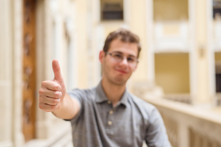 Happy blurred man with thumbs up in the buildingの写真素材