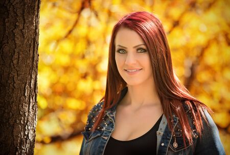 Charming woman portrait in autumn park a sunny day