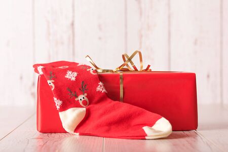 Red gift box and christmas socks on a wooden backgroundの写真素材