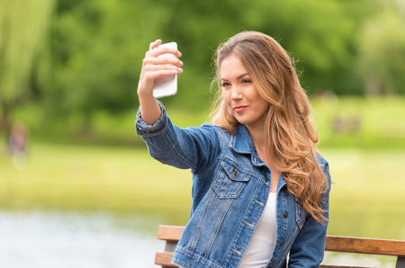 Beauty woman taking selfie with her phone in the natureの写真素材
