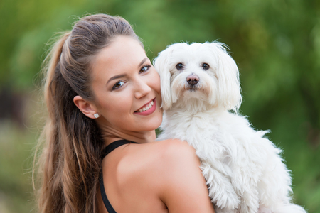 Bichon bolognese dog with beautiful owner in the park