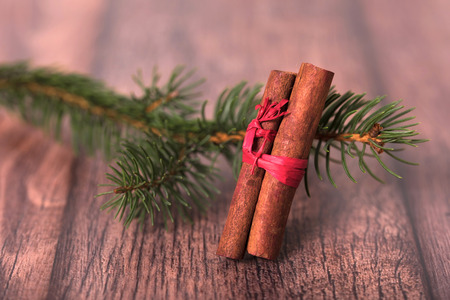 Pine branch with cinnamon on wooden background. Christmas conceptの写真素材