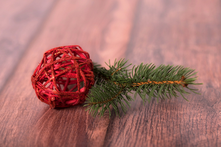 Red decoration ball with pine branch on wooden textured backgroundの写真素材