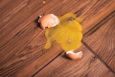 Broken egg on the brown floorの写真素材