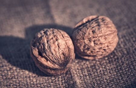 Walnut on sackcloth background. Dark toned photo