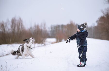 Young boy and his dog in the nature a winters dayの写真素材