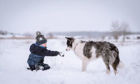 Young boy and his dog in the nature a winters day