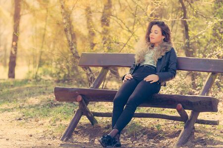 Beautiful woman relaxing on bench in the parkの写真素材