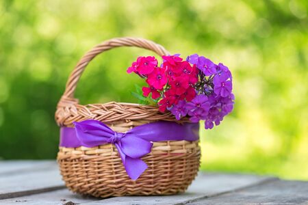 Beauty flowers in basket on a wooden tableの写真素材