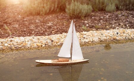 Small model sailboat on the garden lakeの写真素材