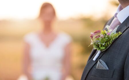 Small wedding bouquet on groom's tuxedo. Closeup photoの写真素材