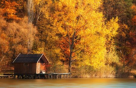 Wooden house in autumn nature, near the lakeの写真素材