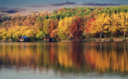 Wooden houses in autumn nature, near the lakeの写真素材