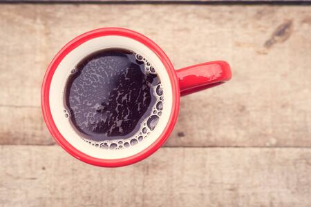 Cup of black tea on a wooden background. Top of view