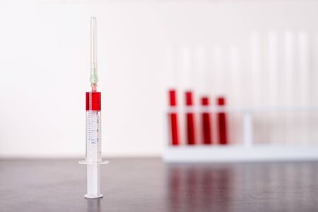 Blood sample in a syringe on the table in the laboratoryの写真素材