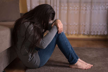Sad woman watching tv, relaxing at home