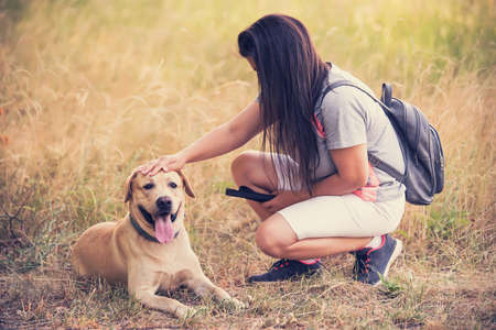 Brown hair woman with her labrador retriever dog in the natureの写真素材