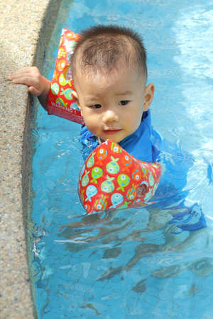 Asian baby at pool edgeの写真素材