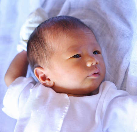 Asian baby awake on bedの写真素材