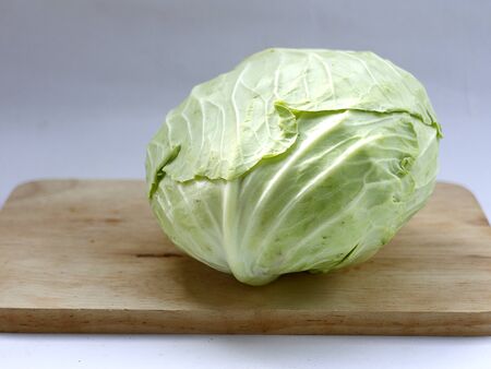 green cabbage on wood cutting board