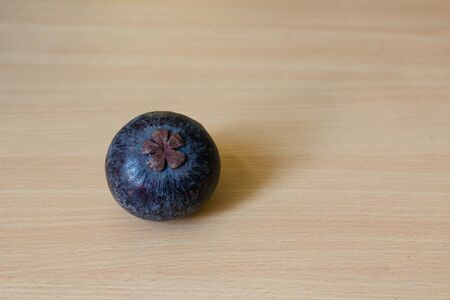 Fresh mangosteen bottom view place on a wooden table.の写真素材