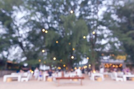 Pastel blurred background of beach restaurant with tree and seat.の写真素材
