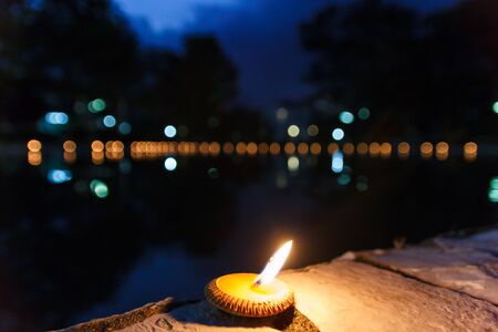 Little candle on ground beside pond.の写真素材