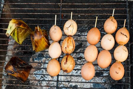 Grilled eggs in stick.With grilled pork in pandan.の写真素材