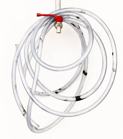 Red faucet and water rubber tube on white background..の写真素材