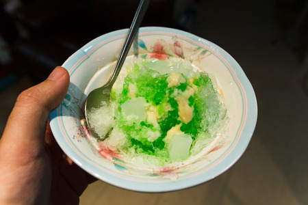 Green shaved ice with jelly on hand.の写真素材
