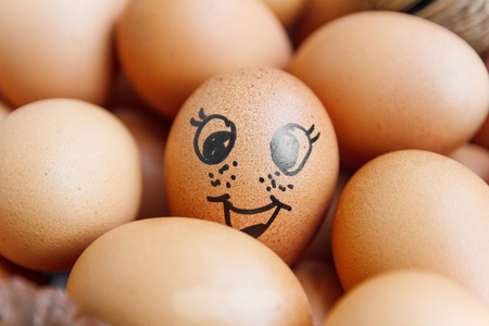 Smiling face on egg with hay and pine in the box.の写真素材