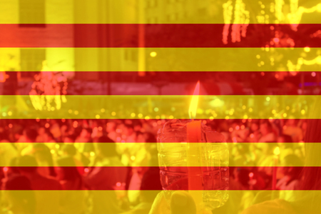 Color of Catalan flag with people holding candle in background.の写真素材