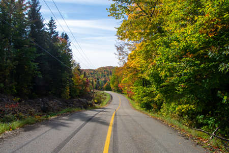 Fall colors in the Canadian countryside with road in the province of Quebecの写真素材
