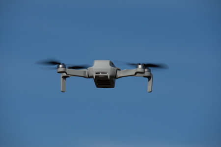 Drone in mid-flight in the blue autumn skyの写真素材