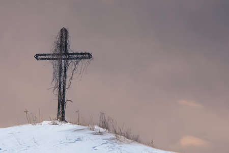 Wayside cross on a snowy mound during the Canadian winter in Quebec