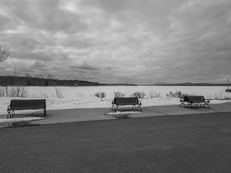 Bench on a dock in winter waiting for spring near a lake in Canadaの写真素材