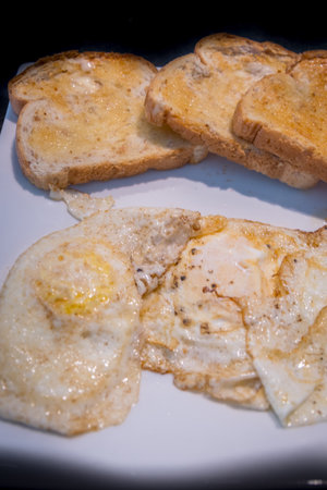 Three eggs and toast served on the table for breakfastの写真素材