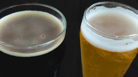 Pale and dark beer, very cold, served on the tableの写真素材