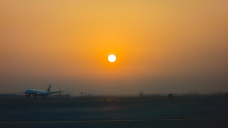 A plane landing at Dubai Airport, United Arab Emirates, at sunrise.の写真素材